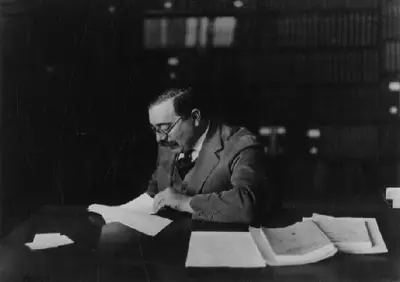 Wiener working at his desk reviewing papers in a library