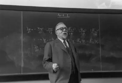 Wiener gesturing while lecturing in front of mathematical equations