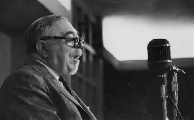 Wiener speaking at a microphone during a lecture or conference