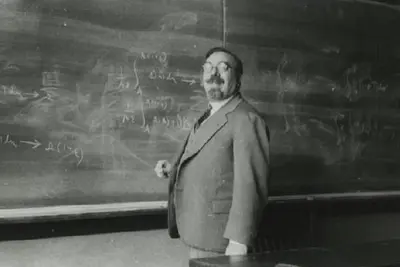 Younger Wiener standing at a chalkboard with mathematical notations