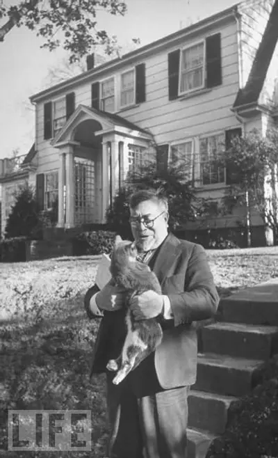 Wiener holding a cat outside his home, from LIFE magazine